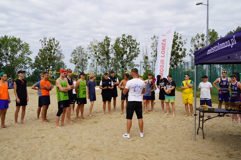 Zdjęcie przedstawia zawodników grających w Turnieju Siatkówki Plażowej.