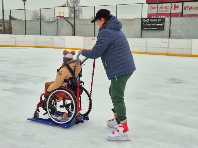 zdjęcie osoby na wózku oraz osoby towarzyszącej na lodowisku