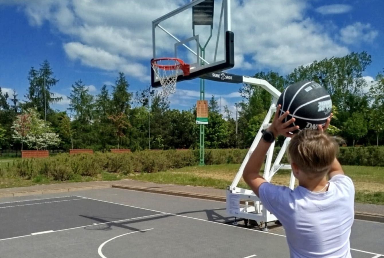 zdjęcie chłopiec rzucający piłkę do kosza