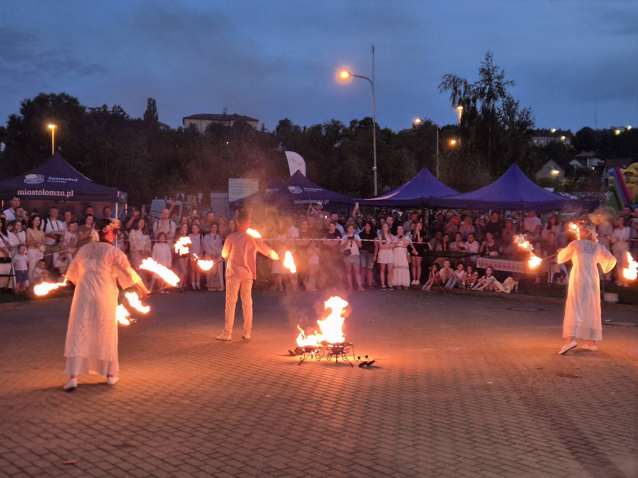 Na zdjęciu teatr ognia spektakl i w tle publiczność na bulwarach