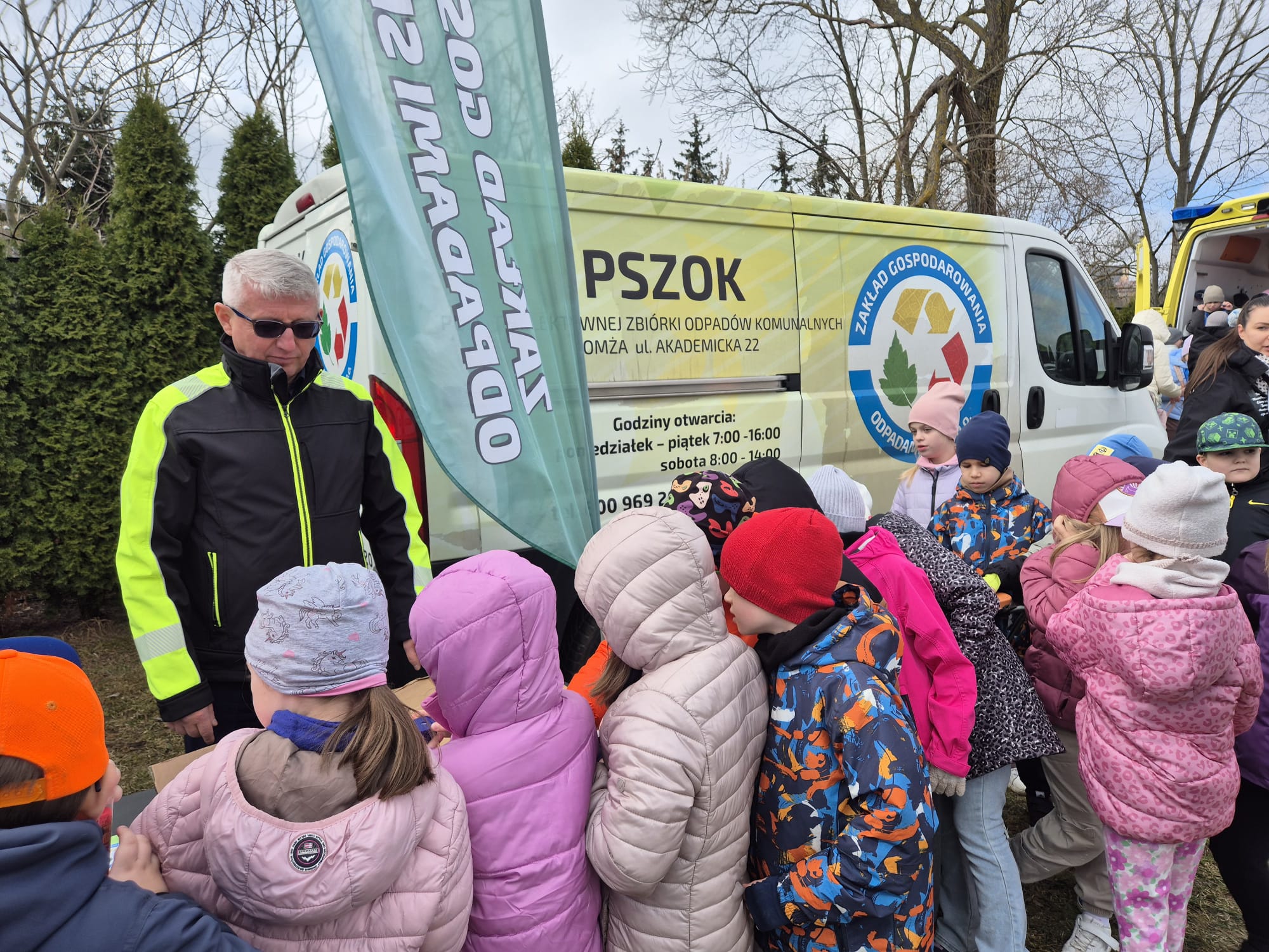 dzieci na tle stoiska edukacyjnego Zakładu Gospodarowania Odpadami